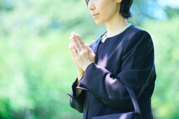 喪服姿で合掌する女性