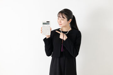 電卓を持つ喪服の女性